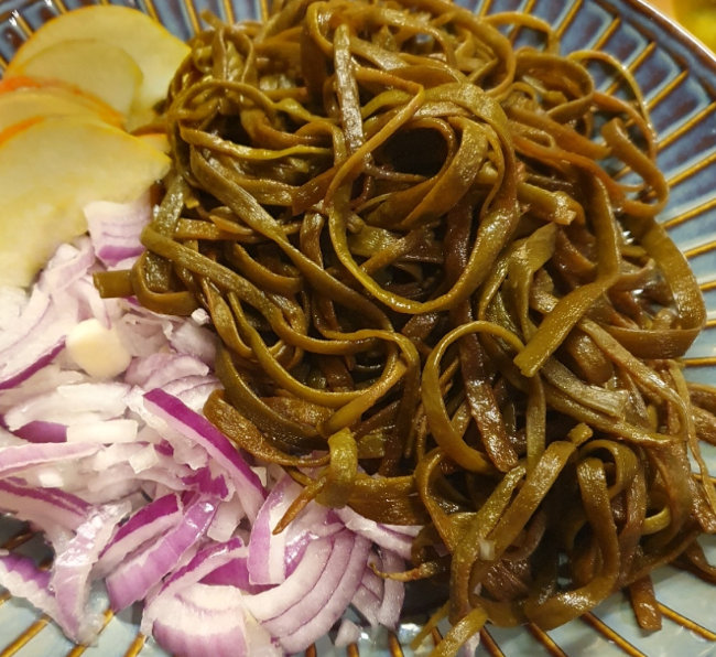 Wild Irish Sea Spaghetti cooked on a plate with sliced onion and apple